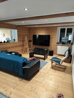 A modern living room with a large flat-screen TV, a sofa, a coffee table, and a chair. - abundance, Stone house with land of 2000m2 at the foot of the vercors (La Baume-Cornillane)