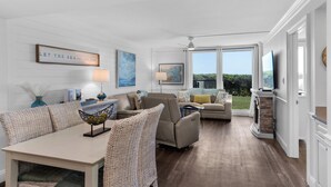 A spacious living room with a dining area, large windows, and a fireplace. - Private Beach Access + Free Seasonal Beach Chairs & Attraction Tickets! (Santa Rosa Beach)