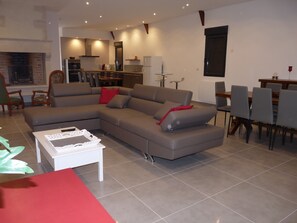Relax in this stylish living room with a large L-shaped sofa, coffee table, and fireplace.