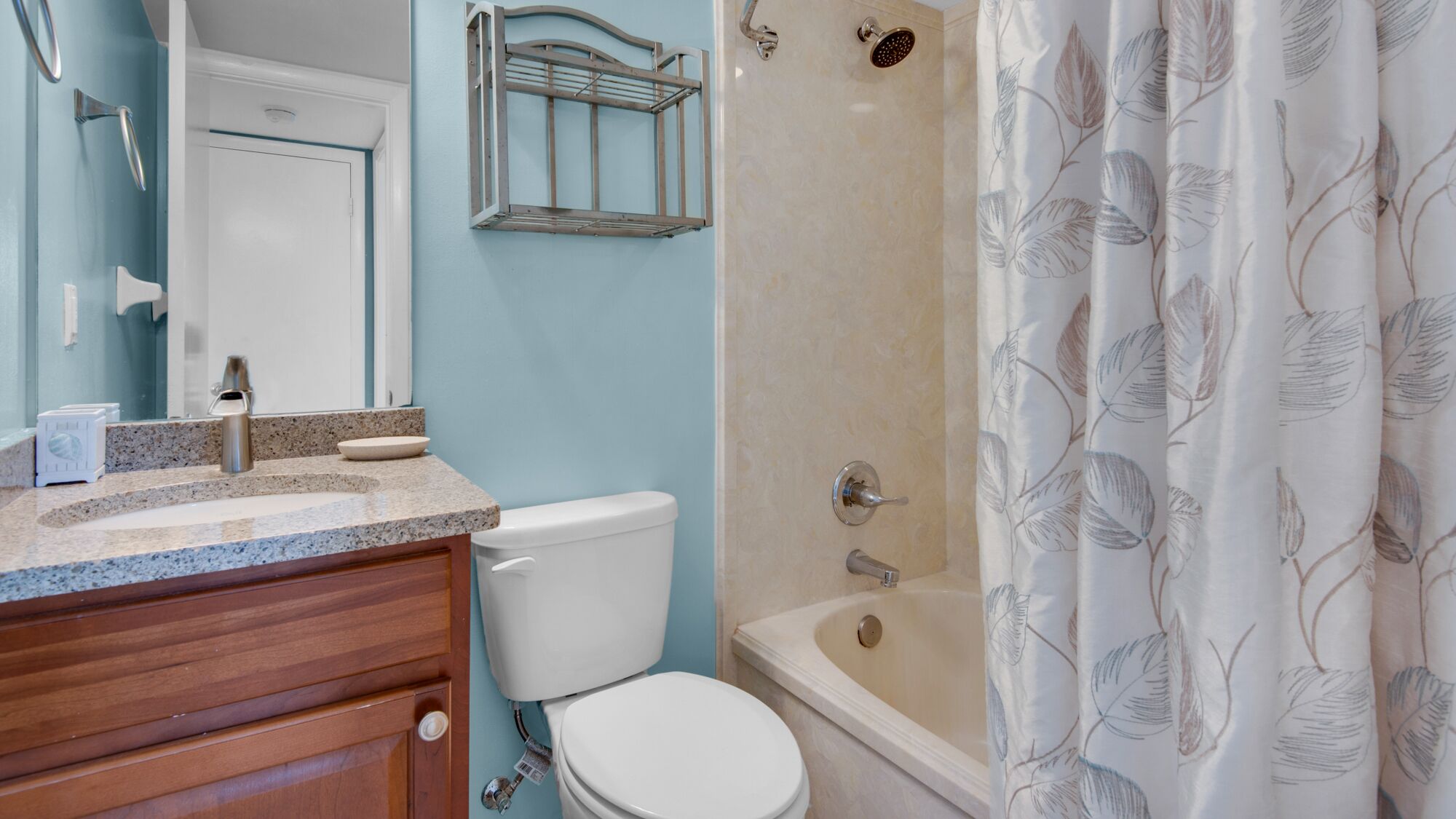 A bathroom with a toilet, sink, and shower.