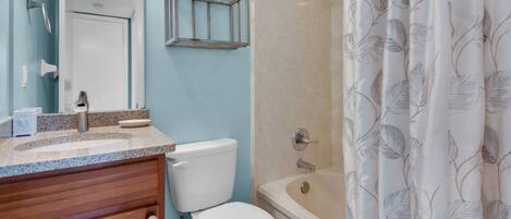 A bathroom with a toilet, sink, and shower.