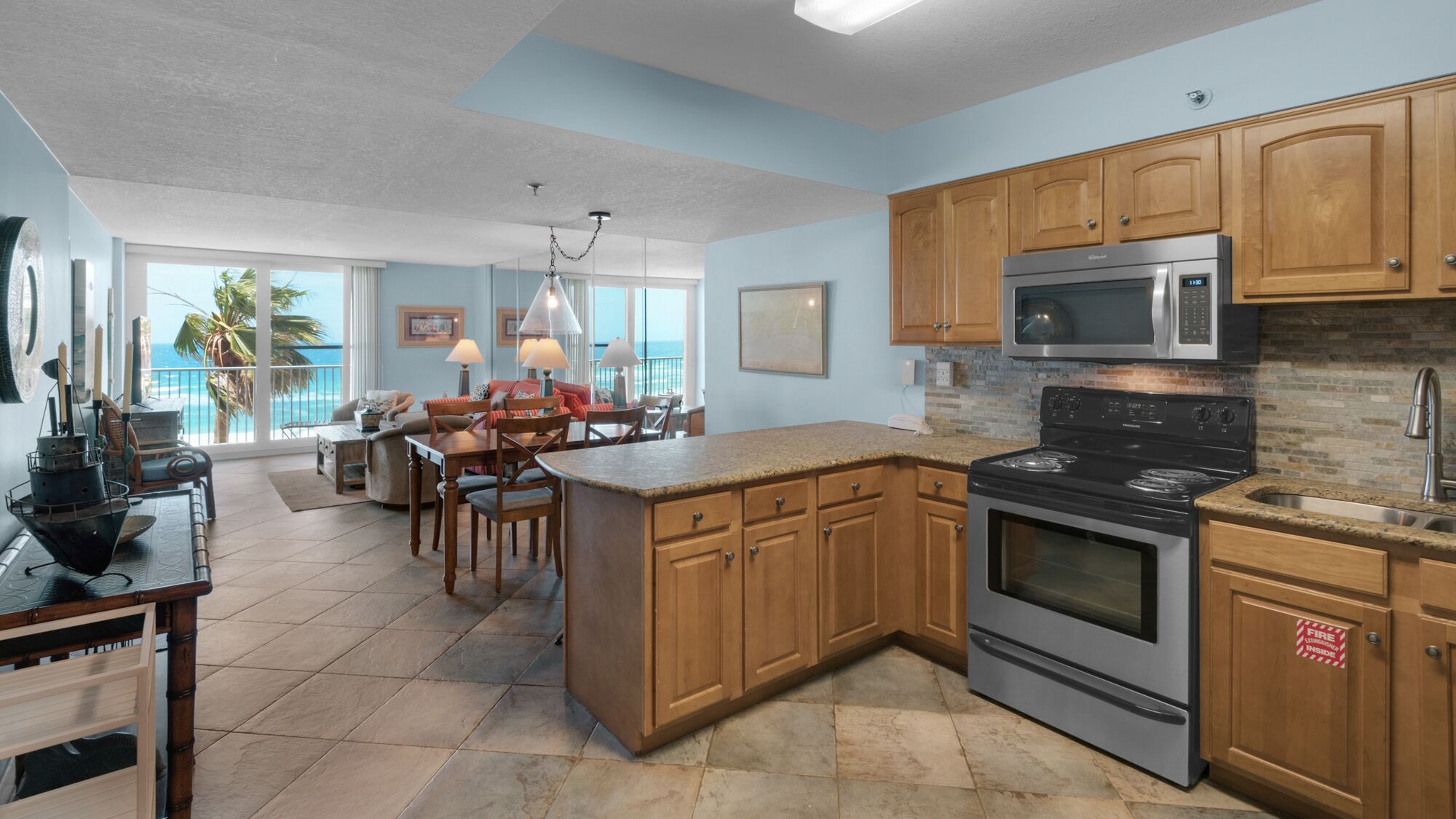 A spacious kitchen with wooden cabinets, a stainless steel stove, and a microwave.