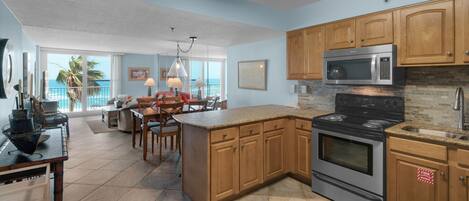 A spacious kitchen with wooden cabinets, a stainless steel stove, and a microwave.