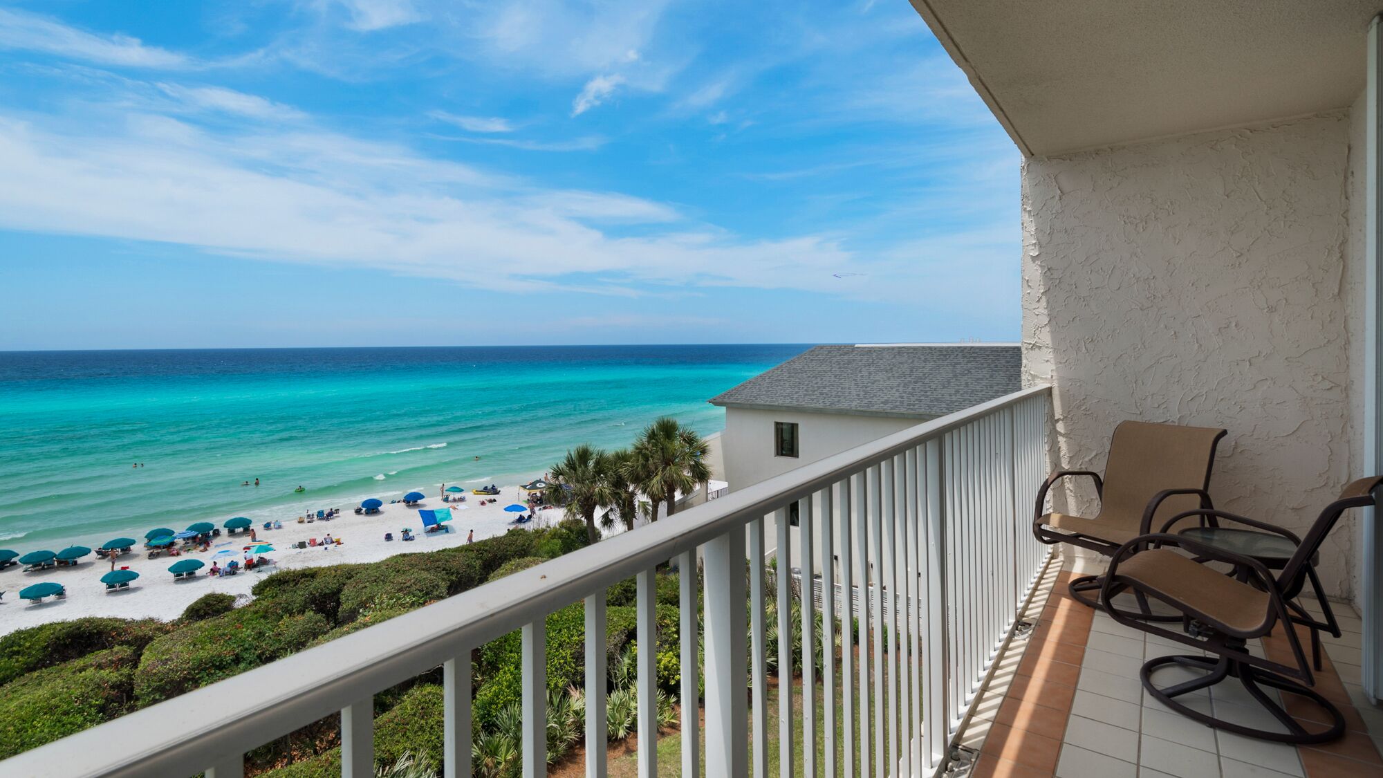 A balcony with a view of a beach and ocean.