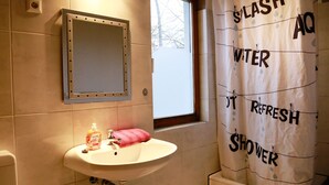 Ett badrum med handfat, spegel och en duschdraperi med text på.