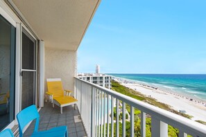 A balcony with a view of a beach and ocean.