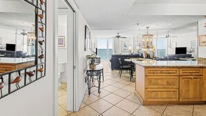 Un'ampia zona giorno con un grande tavolo da pranzo, una cucina con mobili in legno e un balcone con vista.