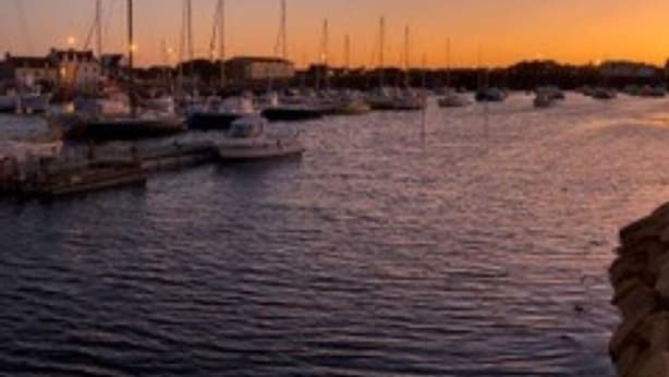 A marina with boats docked at the pier during sunset. - Beautiful renovated house on the waterfront (Treffiagat)