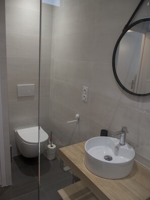 Une salle de bain moderne équipée de toilettes, d’un bidet et d’un lavabo.