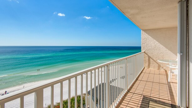 A balcony with a view of a beach and ocean.