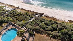 An aerial view of a coastal resort with a swimming pool, lounge area, and a beach path leading to the shore. - Gulf Front, Private Beach w/ Beach Setup, Pool + Free Attraction Tickets! (Santa Rosa Beach)