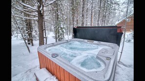 Ein Whirlpool inmitten eines verschneiten Waldes.