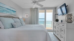 A bedroom with a bed, a ceiling fan, a TV, and a view of the ocean. - Gulf Front w/ Private Beach, Free Seasonal Beach Chairs & Attraction Tickets! (Santa Rosa Beach)