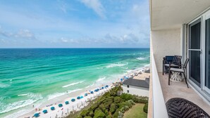 A balcony with a view of the ocean, beach umbrellas, and a patio area with chairs. - Gulf Front w/ Private Beach, Free Seasonal Beach Chairs & Attraction Tickets! (Santa Rosa Beach)