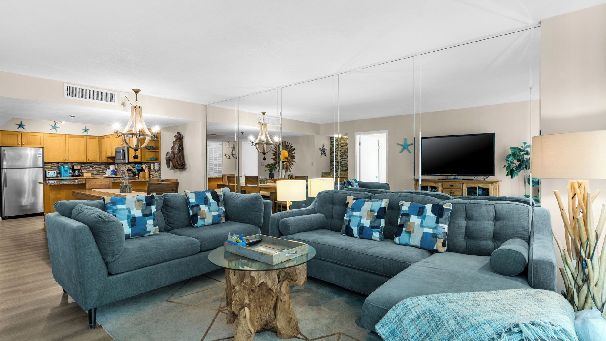 A modern living room with a grey sectional sofa, a wooden coffee table, and a TV in the background.