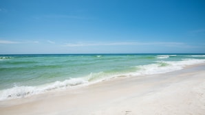 A beach with clear blue water and a sandy shore. - Dog Friendly Gulf-Front Condo in Seagrove Beach, Sleeps 6 + Free Tickets! (Santa Rosa Beach)