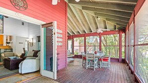 A covered porch with a dining table and chairs, a ceiling fan, and a view of the outdoors. - Beautiful Seaside Cottage, Sports Club, Sleeps 6 + Free Attraction Tickets! (Seaside)