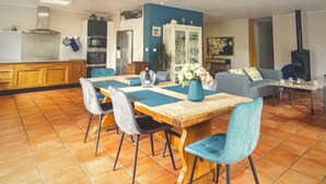 A spacious living area with a dining table, chairs, a sofa, and a fireplace.