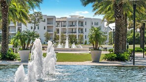 Relax amidst a serene water fountain surrounded by lush greenery and palm trees.