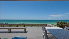 Enjoy the ocean view from our elevated deck, featuring benches and a table for a relaxing outdoor space.