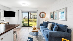 A modern living room with a sofa, coffee table, and artwork on the wall. - 1st Floor, Gulf Side in Seagrove,  Sleeps 6 + Free Attraction Tickets! (Santa Rosa Beach)