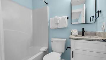 A modern bathroom with a bathtub, toilet, and sink.