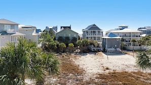 A beachfront property with multiple houses, a sandy beach, and palm trees. - Modern Updates, Family Friendly, Near to Beach,2 Pools, Tennis +Free Tickets! (Santa Rosa Beach)