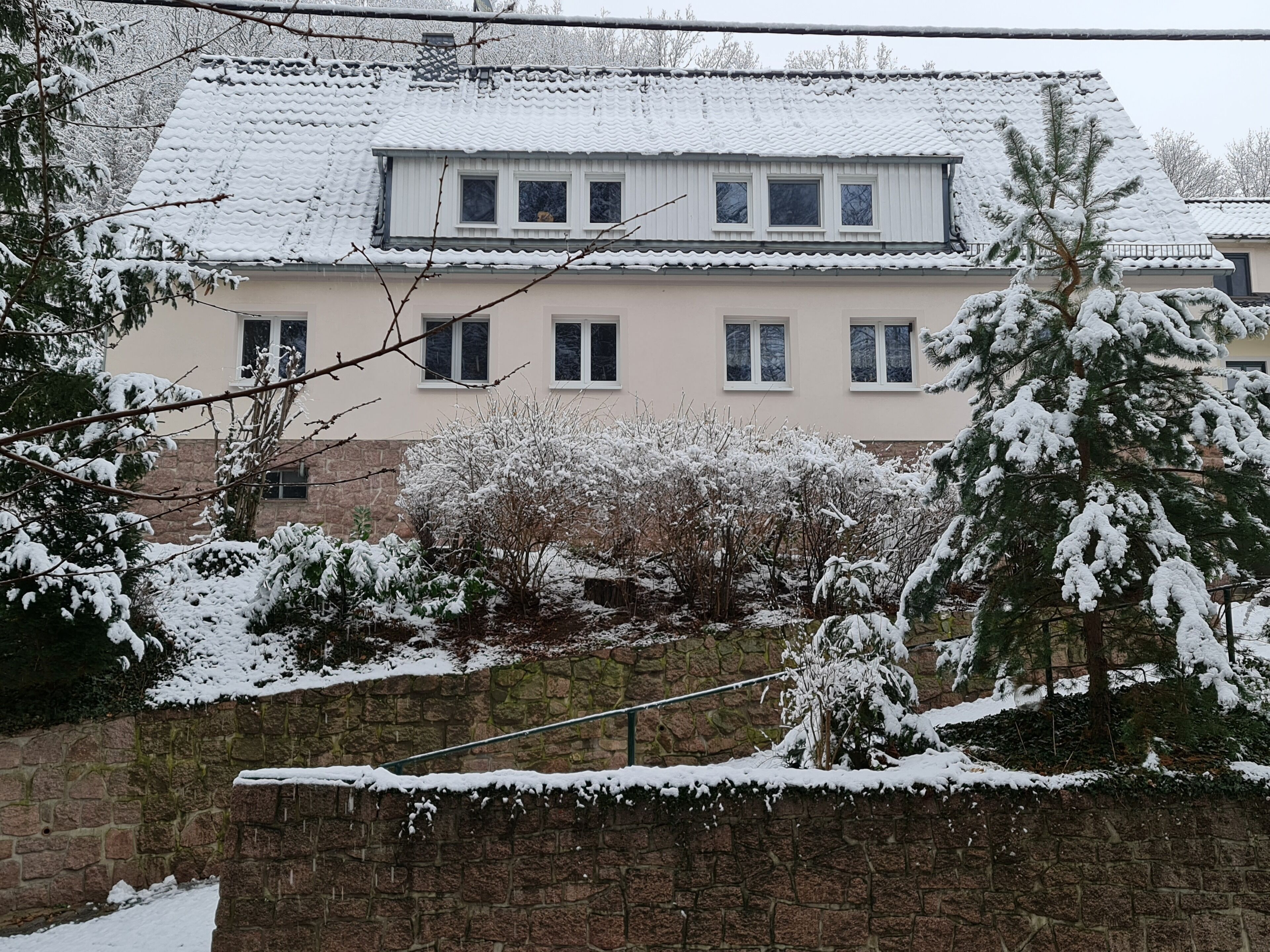 Un bâtiment à deux étages, doté d’un toit recouvert de tuiles et de nombreuses fenêtres.