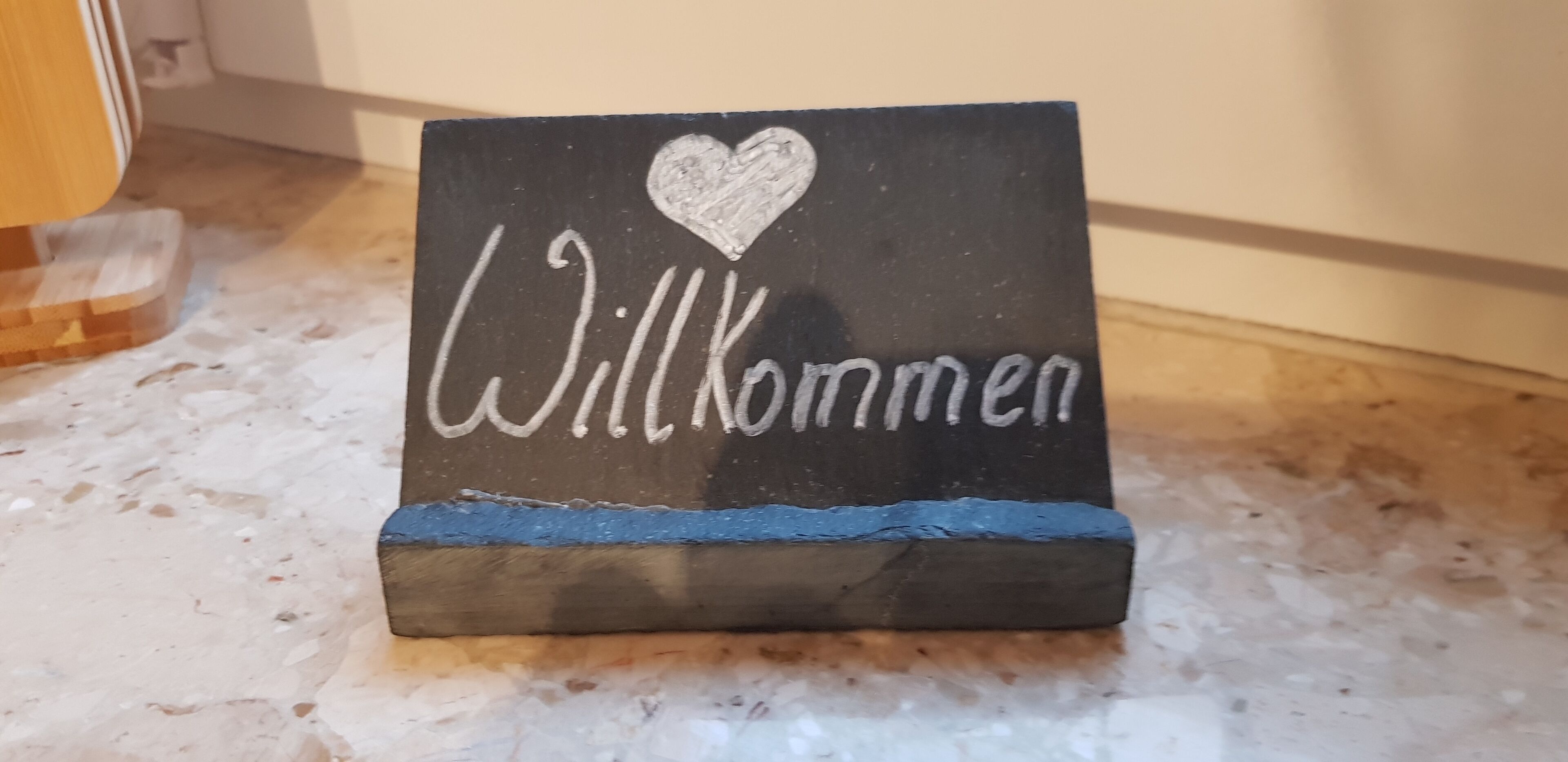 En velkomstskilt med teksten 'Willkommen' og et hjerte.