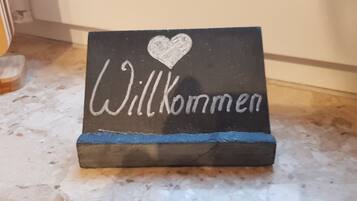 En velkomstskilt med teksten 'Willkommen' og et hjerte.