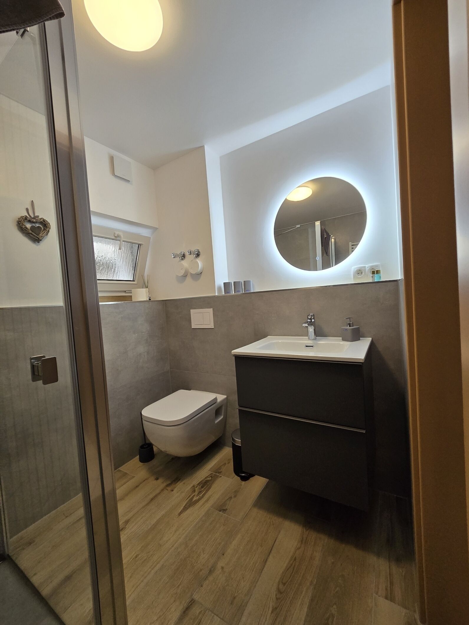 A modern bathroom with a toilet, sink, and shower.