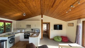 Un acogedor interior de cabaña con cocina, comedor y sala de estar.