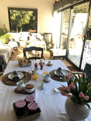 Ein Frühstückstisch mit Stühlen und Blick ins Freie.