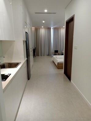 A modern hotel room with a kitchenette, a bed, and a bathroom. - Luxury Scenia Bay Apartment with Seaview (Bac Nha Trang)