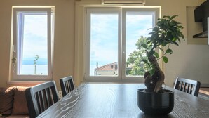 Ein Essbereich mit Tisch, Stühlen und einer Zimmerpflanze.