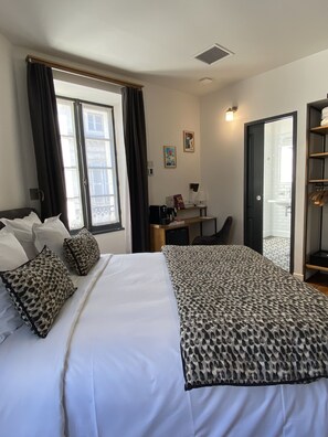 A hotel room with a bed, a desk, and a wardrobe. - Appart Hôtel - Angoulême - Hyper Centre - VILLA CÔTÉ PLATEAU (Angouleme)