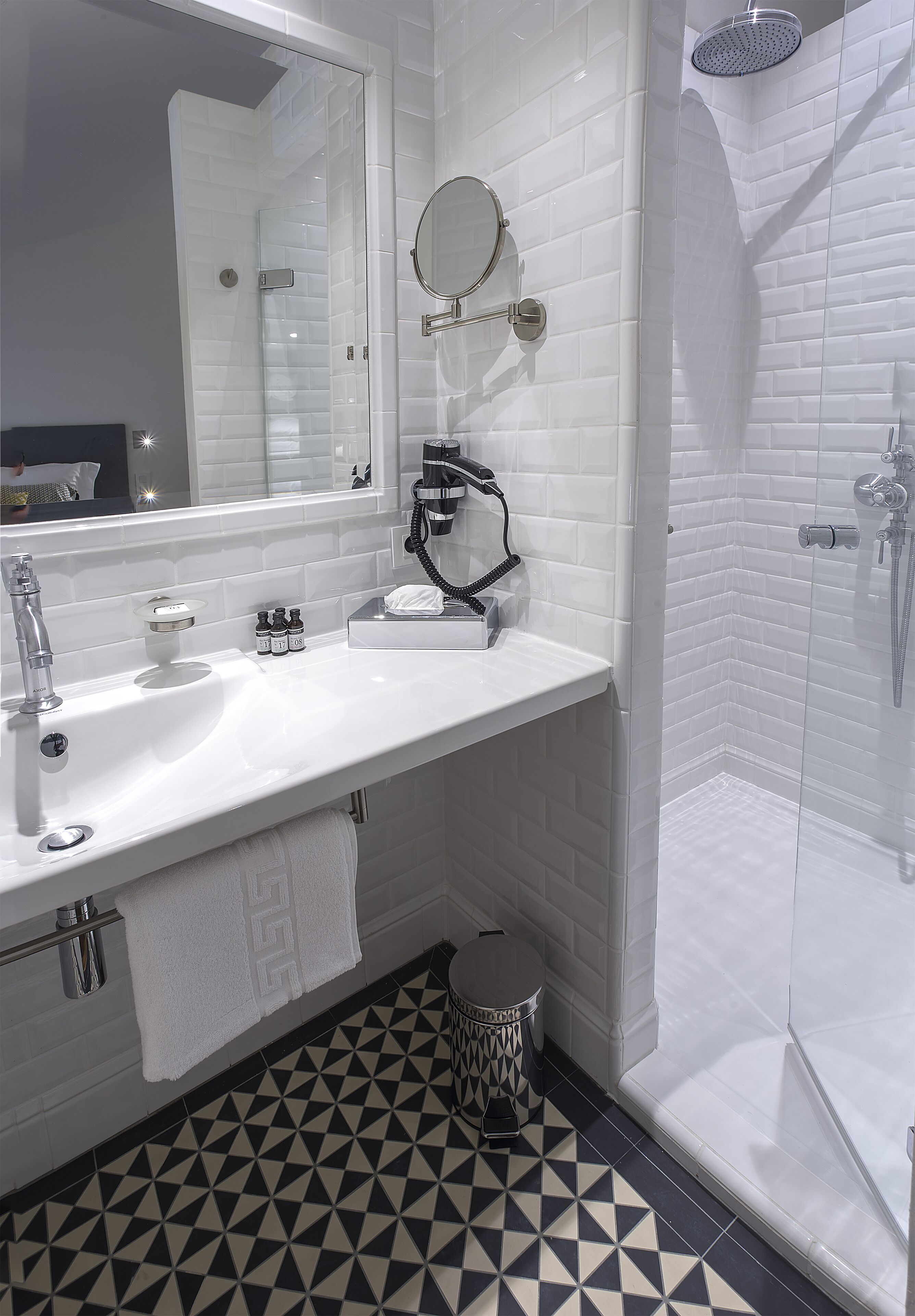 A bathroom with a white sink, mirror, and shower.