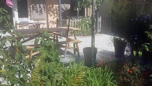 An outdoor patio area with wooden furniture and a large umbrella.