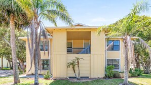 A two-story building with a covered porch and a staircase leading to the upper level. - Beach Life, ground floor, quiet &clean. 2BR 2 Bath (Saint Augustine)