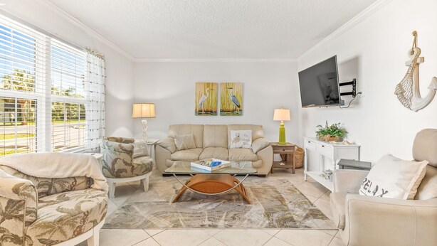 A living room with a sofa, armchairs, a coffee table, and artwork on the wall. - Beach Life, ground floor, quiet &clean. 2BR 2 Bath (Saint Augustine)