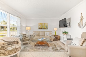 Relax in this inviting living room with a comfortable sofa, armchairs, and a flat-screen TV.