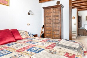 Ein Schlafzimmer mit einem großen Bett, einem Holzschrank und einem Bild an der Wand.
