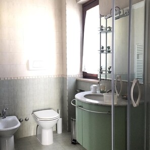 Een badkamer met toilet, bidet en wastafel.