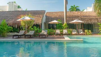Una piscina al aire libre, sillones reclinables de piscina