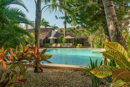 Una piscina al aire libre, sillones reclinables de piscina