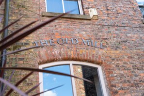 A brick building with the sign 'THE OLD MILL' above a window.
