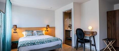 A modern bedroom with a bed, bedside lamps, a chair, and a small table.