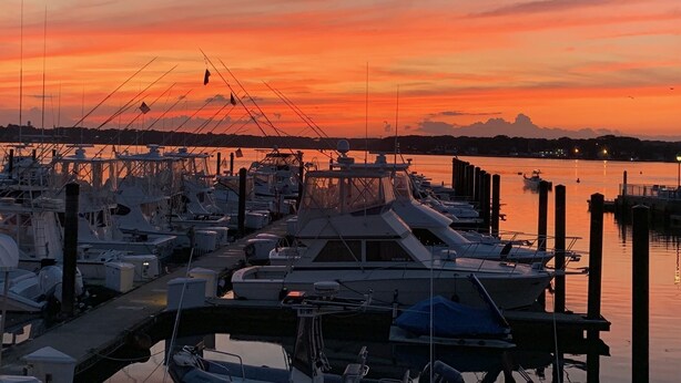 A marina at sunset with boats docked, a pier, and a distant city skyline. - Belmar Shore House by the Sea!  
1.5 Blocks to Beach with 6 badges & Parking (Belmar)
