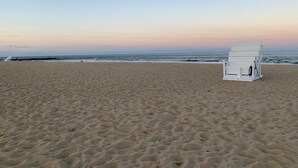 A beach with a white beach chair and a lifeguard tower. - Belmar Shore House by the Sea!  
1.5 Blocks to Beach with 6 badges & Parking (Belmar)