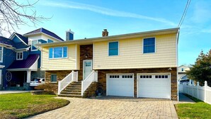A two-story house with a brick driveway, stone foundation, and a front porch. - Belmar Shore House by the Sea!  
1.5 Blocks to Beach with 6 badges & Parking (Belmar)